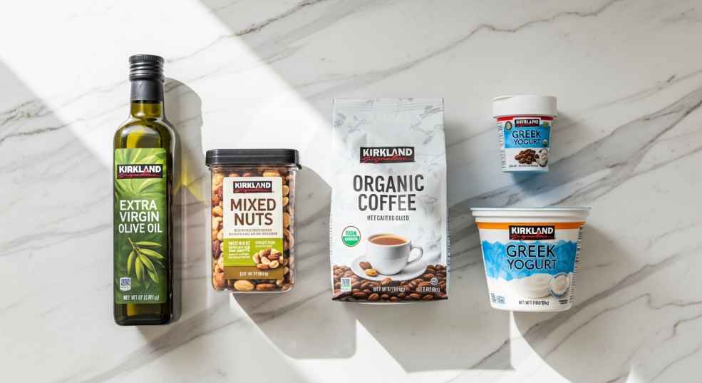 Assortment of Kirkland Signature brand products including olive oil, nuts, and coffee